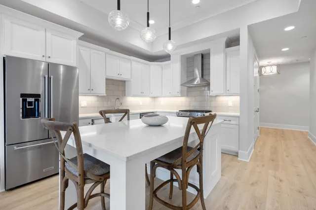 a kitchen with a table chairs refrigerator and microwave