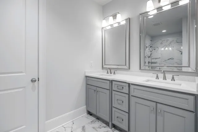 a bathroom with double sink and a mirror