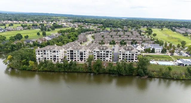an aerial view of a city with lots of residential buildings and lake view in back