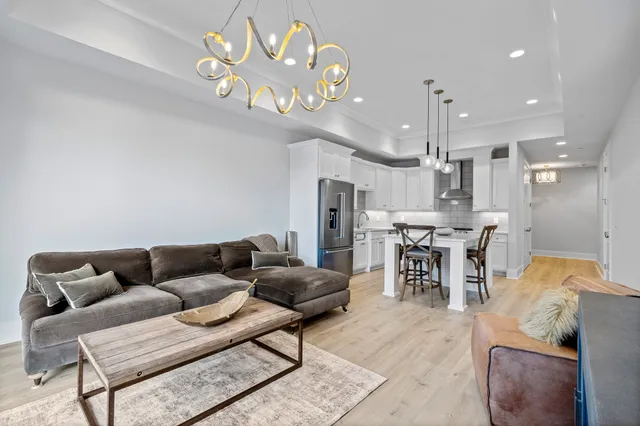 a living room with furniture a chandelier and a flat screen tv
