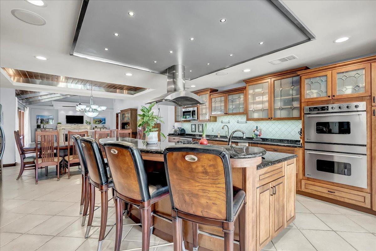 30960 Tower Road Visalia, CA 93292 - Photo 52 of 76 a kitchen with stainless steel appliances granite countertop a stove top oven island a large window and white cabinets