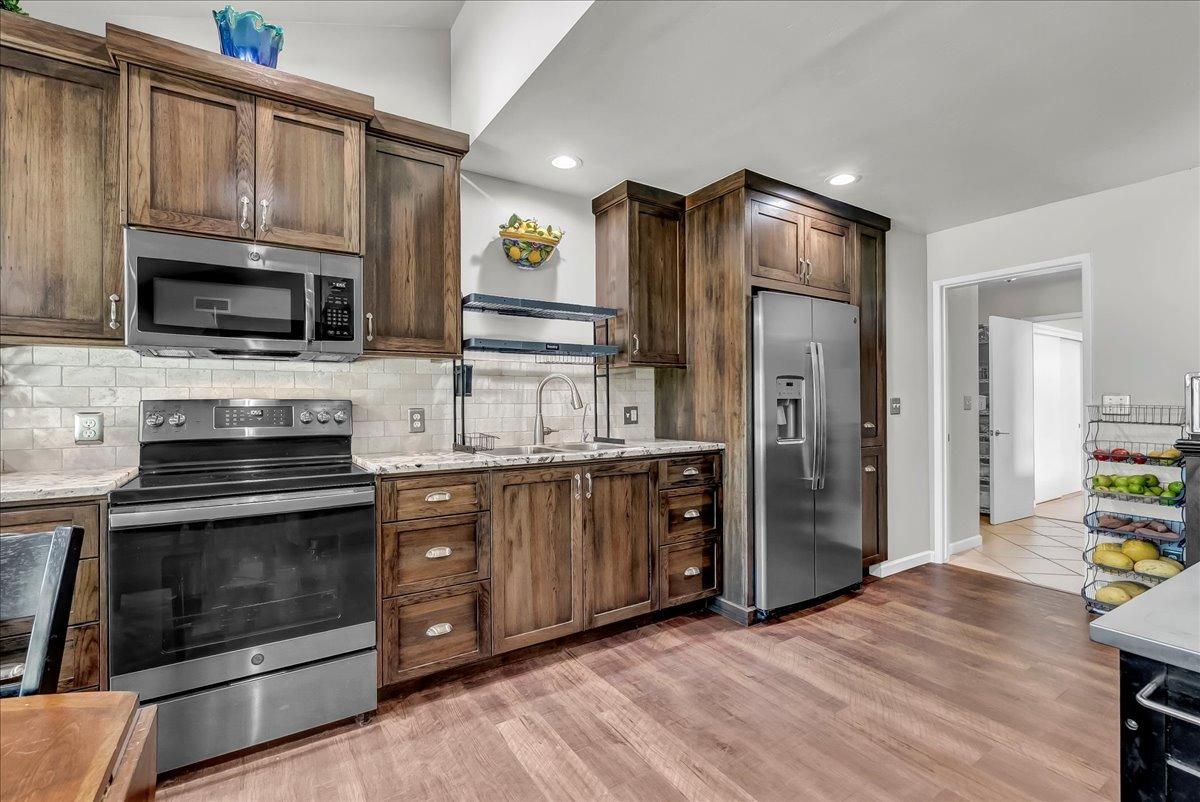 30960 Tower Road Visalia, CA 93292 - Photo 70 of 76 a kitchen with stainless steel appliances granite countertop a stove microwave and refrigerator