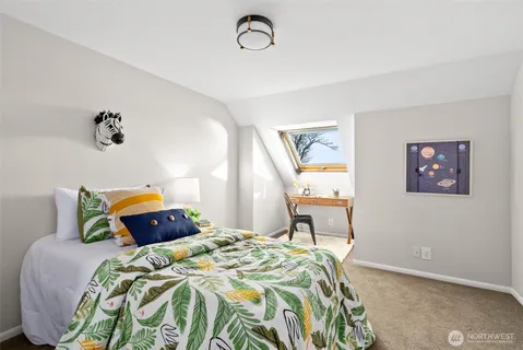 a bedroom with a bed and a painting on the wall