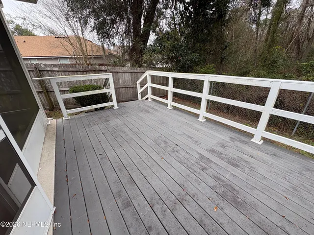 a view of a deck with wooden floor and fence