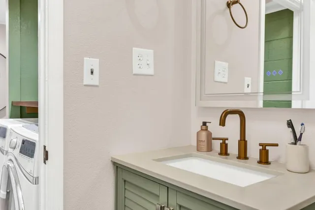 a close view of a sink a faucet and a table in a white room