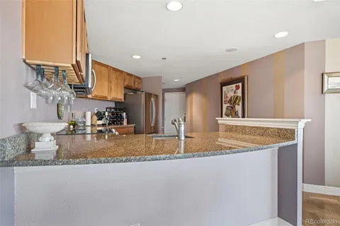 a kitchen with stainless steel appliances granite countertop a stove a sink a refrigerator and a microwave