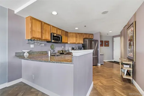 a kitchen with stainless steel appliances granite countertop a refrigerator and a stove top oven
