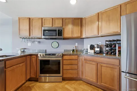 a kitchen with stainless steel appliances granite countertop a refrigerator a stove top oven a sink and dishwasher