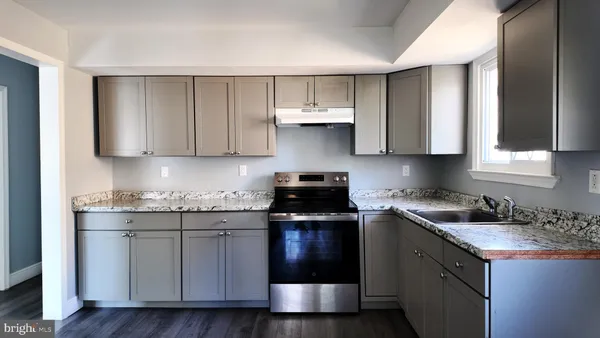a kitchen with stainless steel appliances granite countertop a sink stove and cabinets