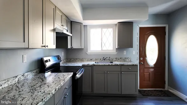 a kitchen with stainless steel appliances granite countertop a sink stove and cabinets