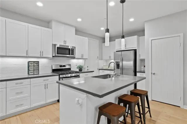 a kitchen with a sink cabinets and wooden floor