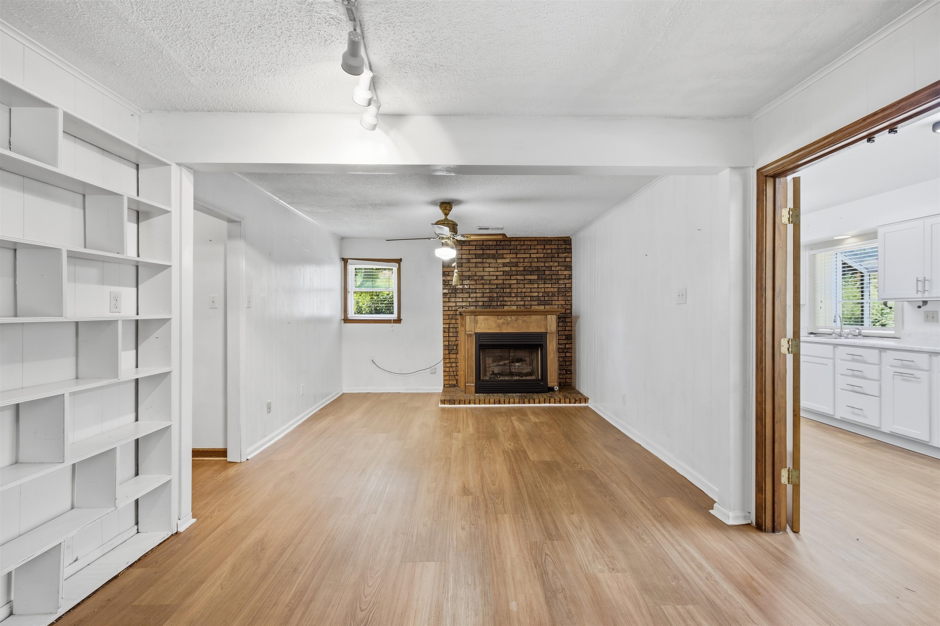 3007 Ruskin Road Bartlett, TN 38134 - Photo 11 of 37 Living area featuring wood-finish flooring, a brick fireplace, and built-in shelving