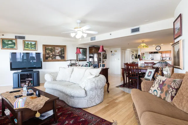 a living room with furniture a flat screen tv and a chandelier