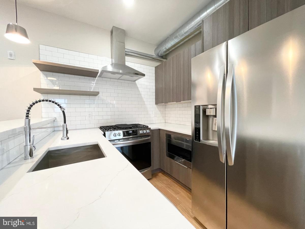 a kitchen with granite countertop stainless steel appliances a refrigerator and a sink