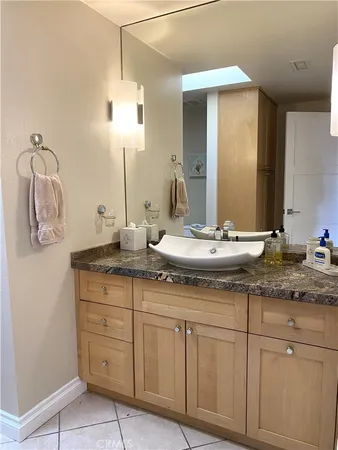 a bathroom with a granite countertop sink and a mirror