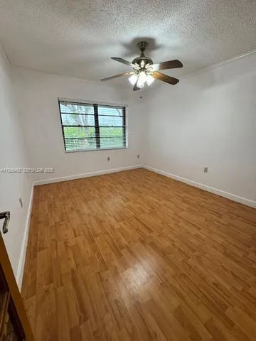 a view of a room with wooden floor and a chandelier