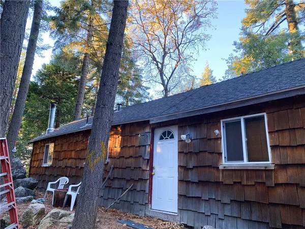 a front view of a house with a tree