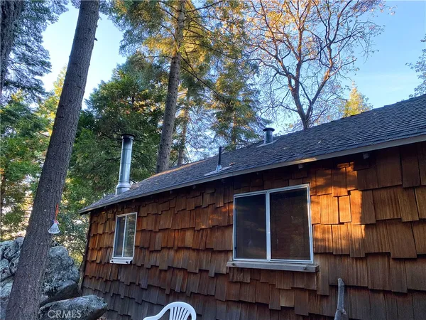 a front view of a house with a tree