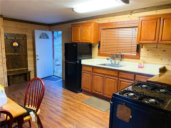a kitchen with stainless steel appliances granite countertop a stove a refrigerator and wooden floors