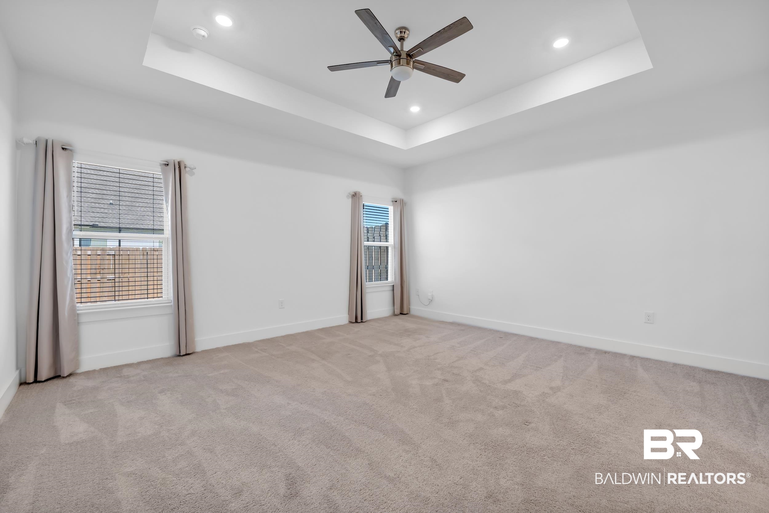 9933 Weller Cove Foley, AL 36535 - Photo 16 of 36 Spacious room featuring a tray ceiling with recessed lighting and a ceiling fan