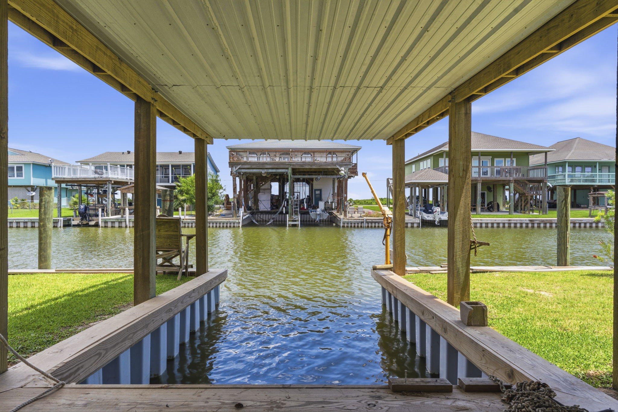 119 Sand Shoals Road Freeport, TX 77541 - Photo 13 of 34 Covered boat slip — pile-supported slip with metal roof, deep-water moorage, and direct canal access from the home's bulkhead.