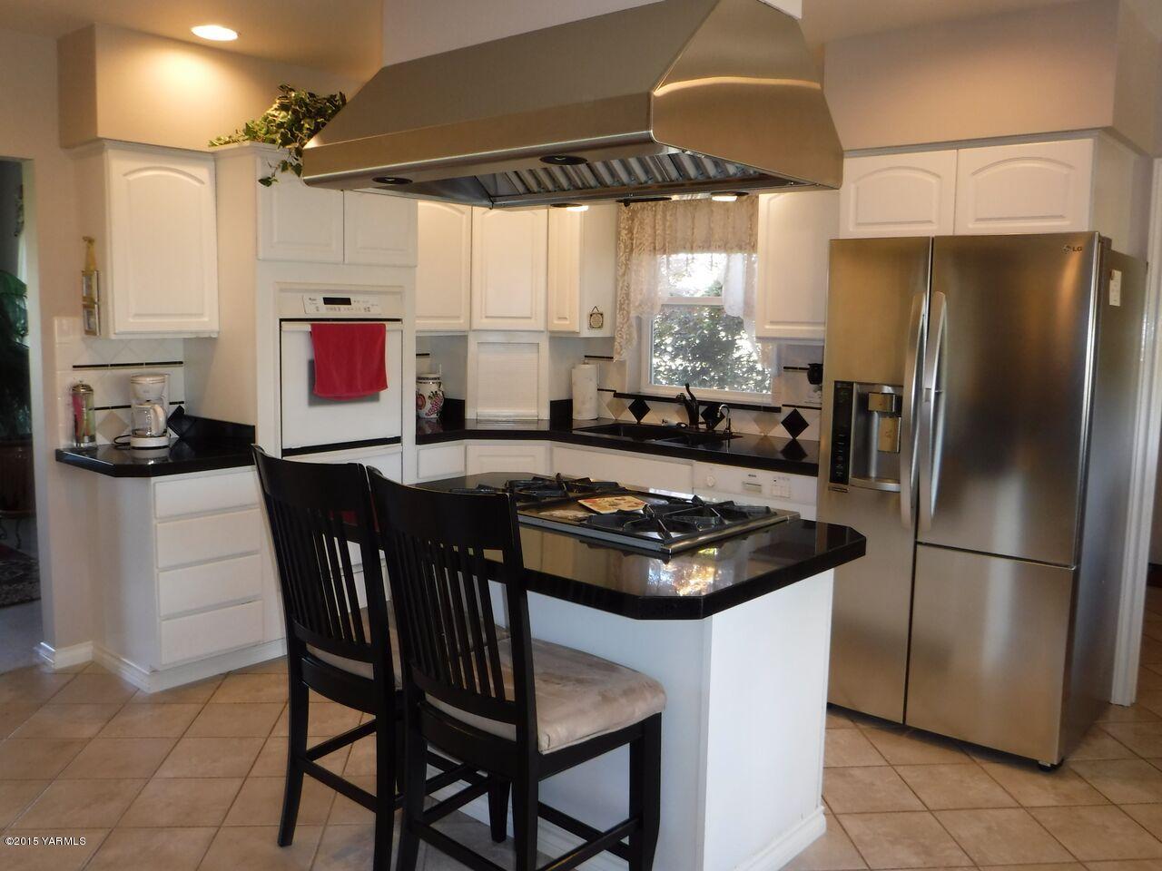 11301 Summitview Ext Road Yakima, WA 98908 - Photo 15 of 45 a kitchen with a refrigerator a stove a dining table and chairs