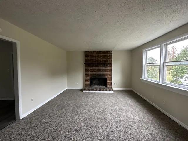 an empty room with fireplace and windows