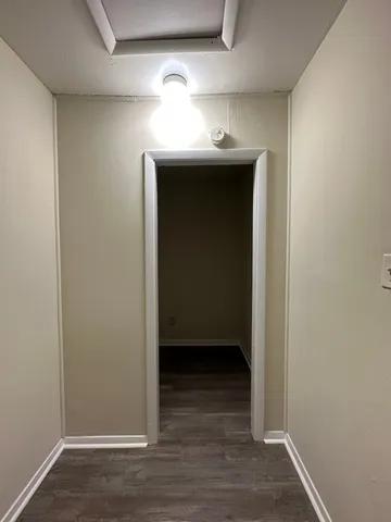 a view of a hallway with wooden floor