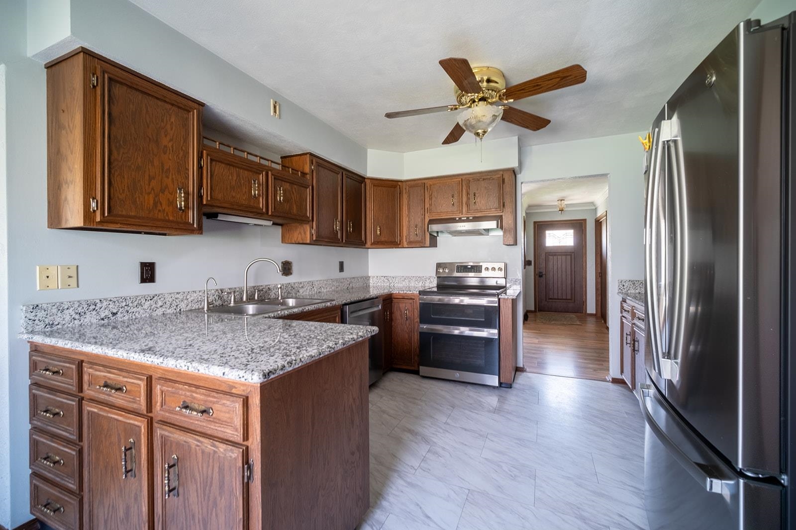 10401 Ray Drive Roscoe, IL 61073 - Photo 17 of 38 a kitchen with a refrigerator a sink and wooden cabinets