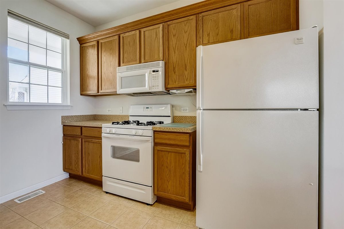 231 Ridge Road North Aurora, IL 60542 - Photo 10 of 31 a white refrigerator freezer and a stove sitting inside of a kitchen