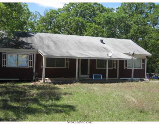 a view of house with yard and sitting area