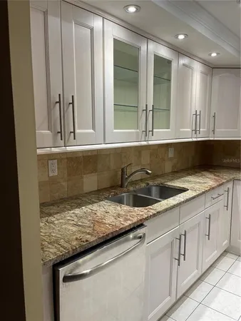 a kitchen with granite countertop sink and cabinets