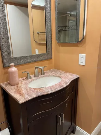a bathroom with a granite countertop sink and a mirror