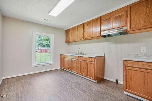 a view of a kitchen with wooden floor and electronic appliances