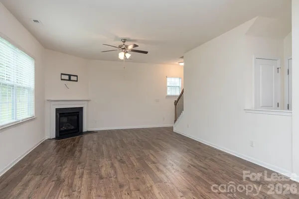an empty room with windows and a fireplace