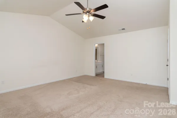 an empty room with a ceiling fan and a window