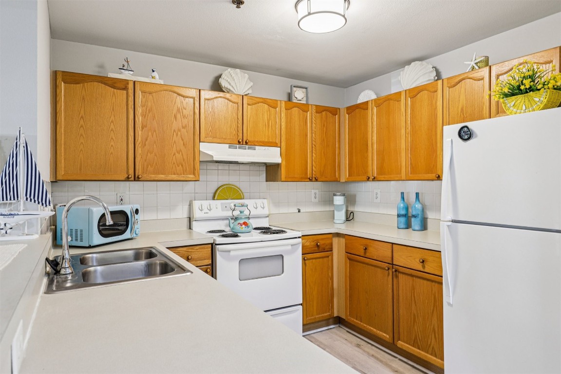 31183 Paradise Cmns, Unit 713 Fernandina Beach, FL 32034 - Photo 14 of 35 a kitchen with a sink a refrigerator and cabinets