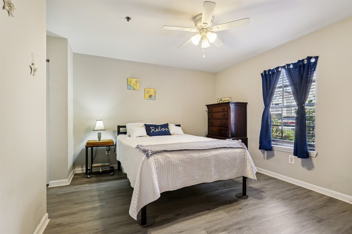 31183 Paradise Cmns, Unit 713 Fernandina Beach, FL 32034 - Photo 17 of 35 a bedroom with a bed a dresser and wooden floor