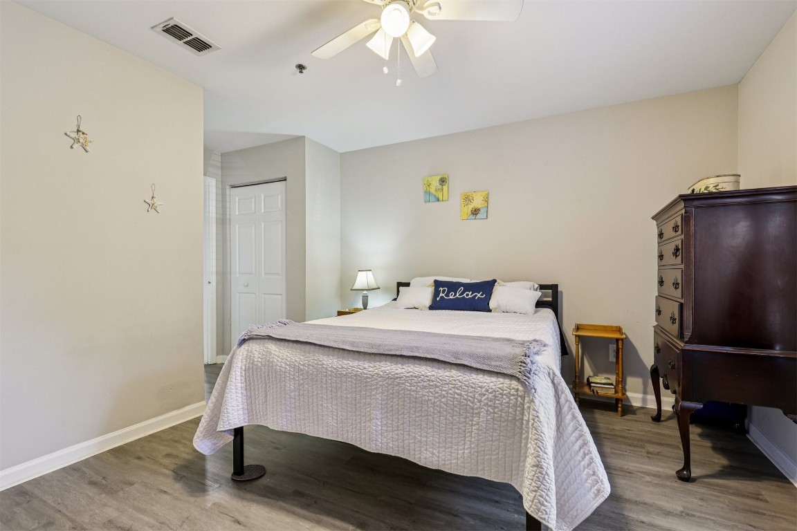 31183 Paradise Cmns, Unit 713 Fernandina Beach, FL 32034 - Photo 18 of 35 a bedroom with a bed and wooden floor