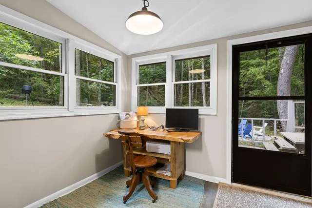 a view of a workspace with furniture and a window