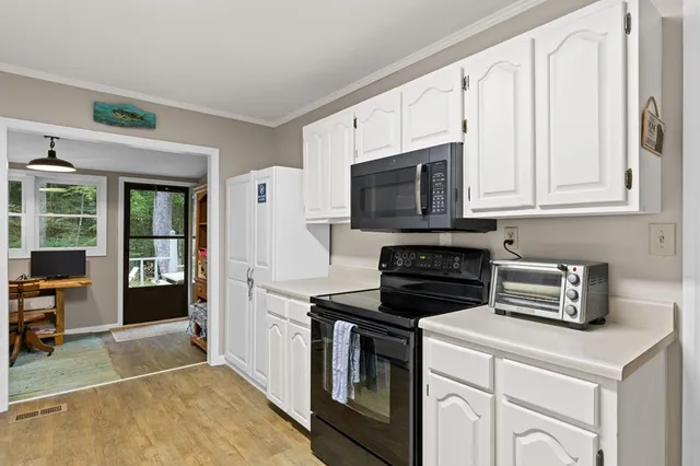 a kitchen with appliances a sink and cabinets