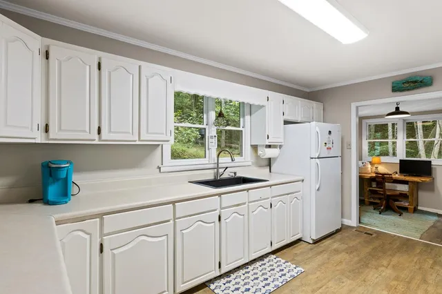 a kitchen with white cabinets and white appliances