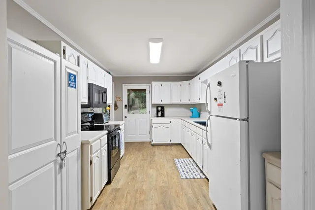 a kitchen with white cabinets and white appliances