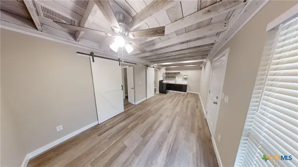 a view of empty room with wooden floor