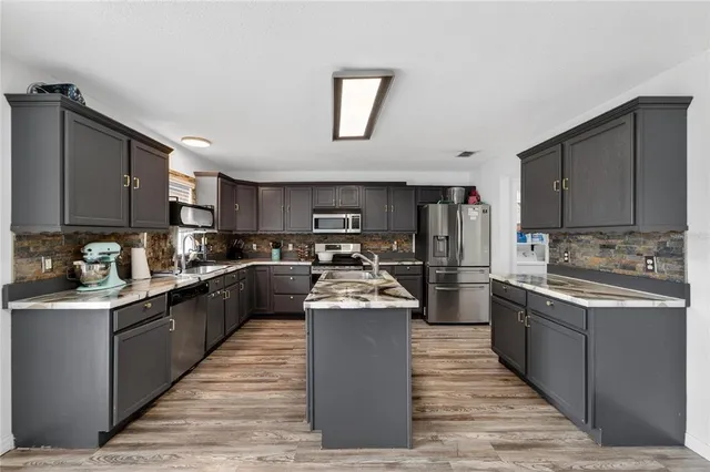 a kitchen with stainless steel appliances granite countertop lots of counter top space a sink and cabinets