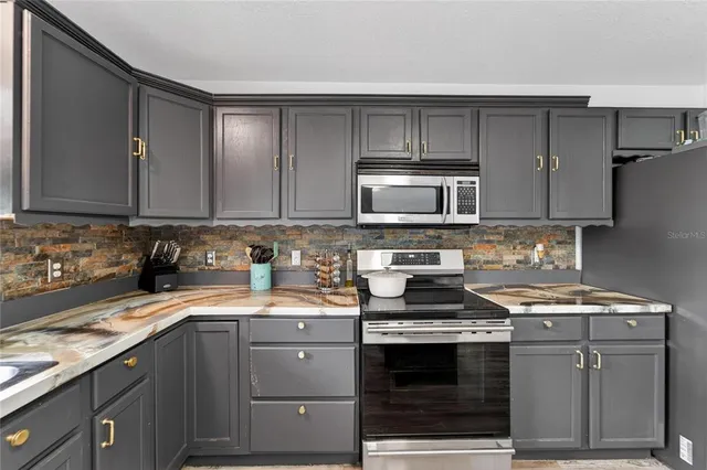 a kitchen with stainless steel appliances granite countertop a sink stove and cabinets