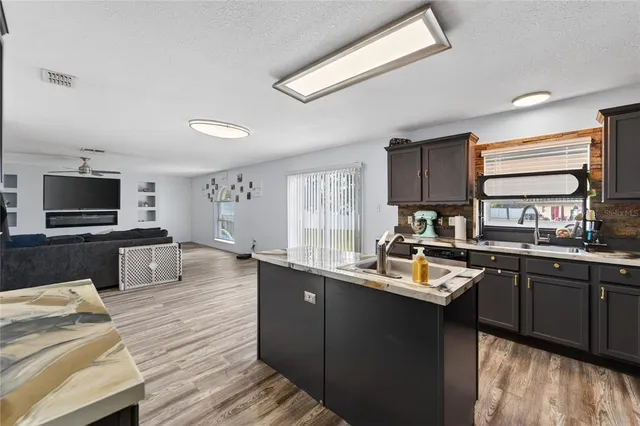 a kitchen with kitchen island granite countertop a sink appliances and cabinets