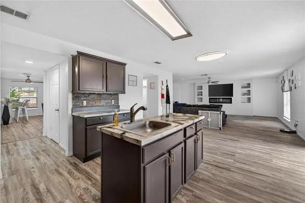 a kitchen with granite countertop a refrigerator cabinets and wooden floor