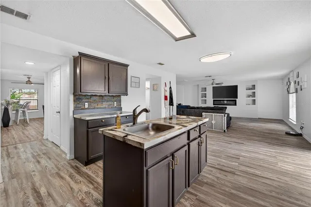 a kitchen with granite countertop a refrigerator cabinets and wooden floor