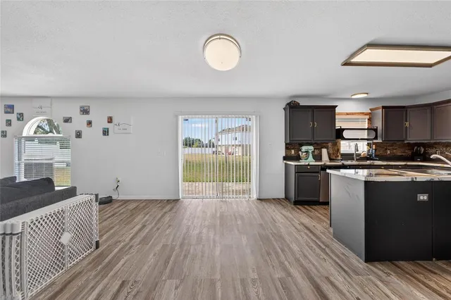 a kitchen with stainless steel appliances granite countertop a refrigerator a stove top oven a sink and dishwasher